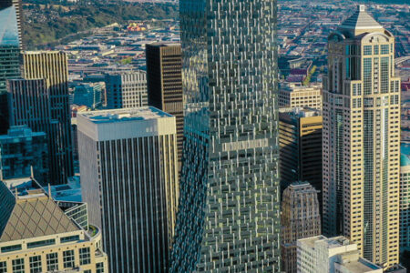 An aerial view of Rainier Square against the Seattle skyline and a cloudless horizon.