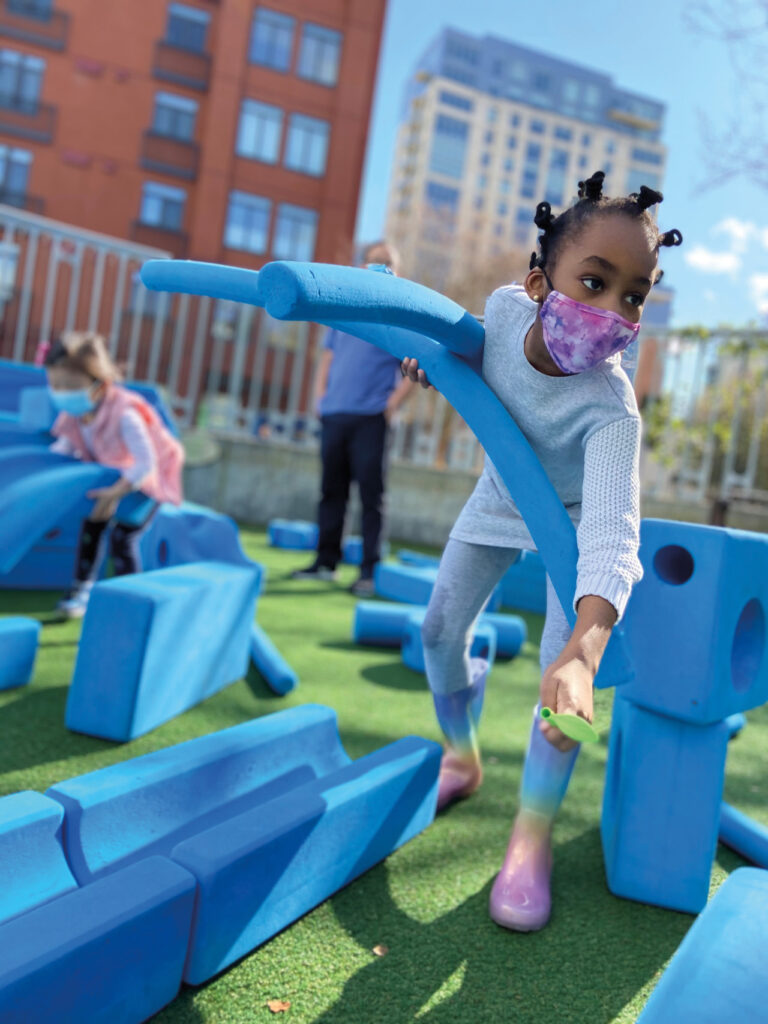 Child playing and building with foam pieces at KidsQuest museum.
