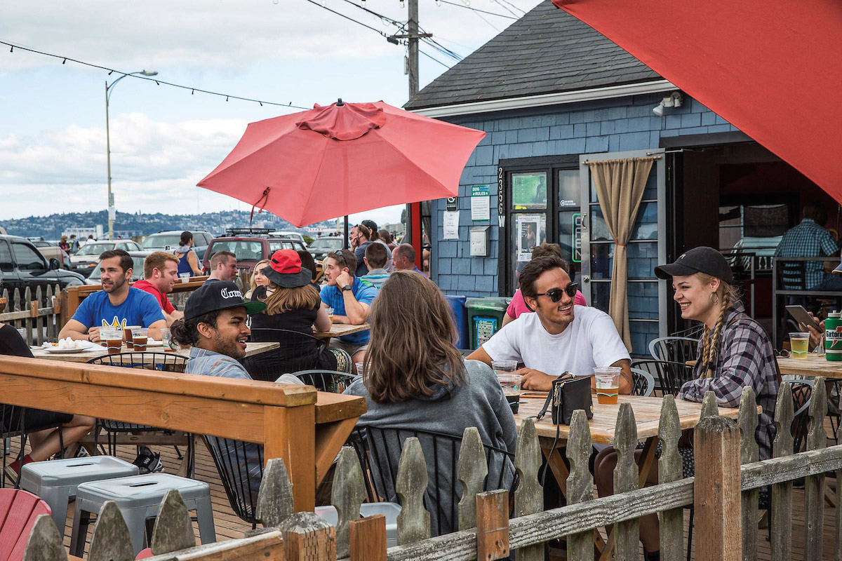 People dining outdoors under red umbrellas
