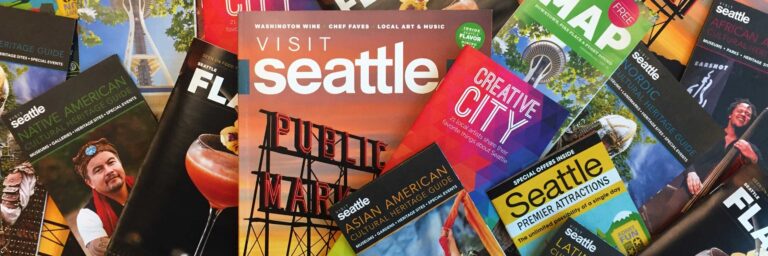 A collection of colorful travel brochures and maps for Seattle, featuring images of landmarks and cultural attractions like Pike Place Market. Prominent titles include "Visit Seattle," "Creative City," and "Seattle Premier Attractions.
