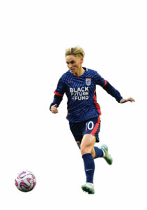 A soccer player wearing a blue and red uniform dribbling a soccer ball.