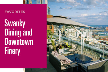 The image shows a stylish rooftop patio with modern seating and large umbrellas, offering a panoramic view of a city's downtown area. The text reads 