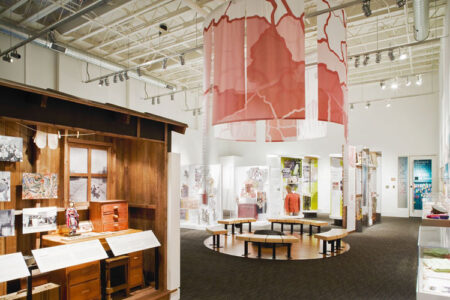 A large, open white space filled with various gallery exhibitions at the Wing Luke Museum.