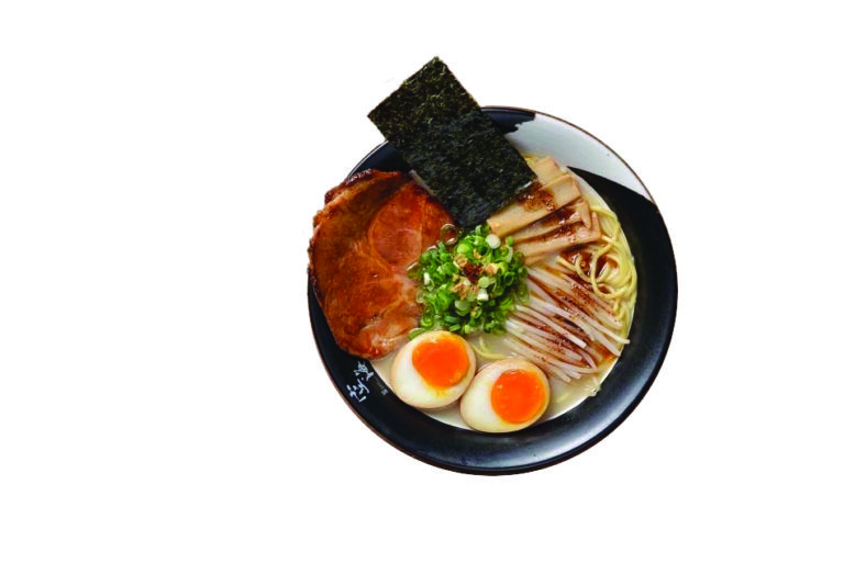 A bowl of ramen with slices of pork, seaweed, soft-boiled eggs, green onions, and bamboo shoots, beautifully arranged over noodles in broth.