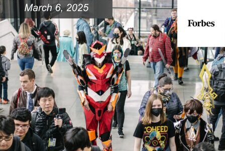 A colorful gathering at a convention center, with attendees in costume. Prominent is a person in a red and black armor cosplay.