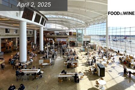 A spacious, sunlit airport terminal food court with many people sitting at tables near large windows; planes are visible outside.