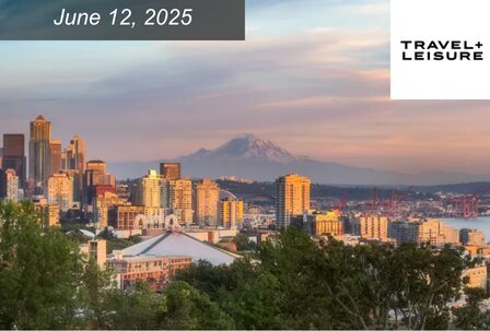View of a city skyline at sunset with a distant mountain in the background.