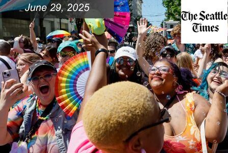 A diverse, joyful crowd celebrates at a Pride parade, some holding rainbow fans and wearing colorful outfits.