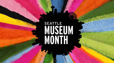 Colorful abstract painting with vivid brush strokes radiating outward from a black silhouette of Seattle's skyline. Text in the center reads 