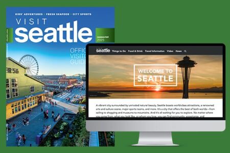 A printed Seattle visitor guide and a computer screen displaying a website with 