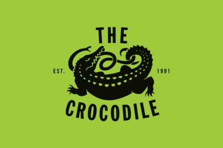 The image shows a black silhouette of a crocodile with the words 