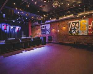 An empty bar lit up with lights with signage hanging on the walls
