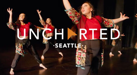 Four dancers in colorful outfits perform energetically on stage. The text "UNCHARTED SEATTLE" is overlaid on the image.