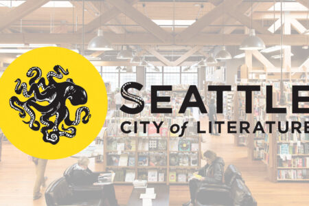 Yellow circle with a black octopus and the text "Seattle City of Literature" overlaying an image of a bookstore with wooden beams. Two people are seated, reading at a table surrounded by bookshelves.