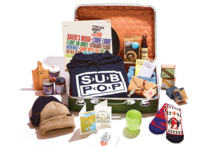 A variety of colorful souvenirs fill an orange suitcase