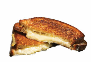 Two halves of a grilled cheese sandwich with golden brown crust and melted cheese oozing out, isolated on a white background.