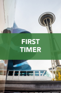 The Space Needle and a monorail in Seattle with the Museum of Pop Culture, overlaid by a green box with white text reading "FIRST TIMER.