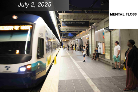 A light rail train arrives at an underground subway station as people wait on the platform.